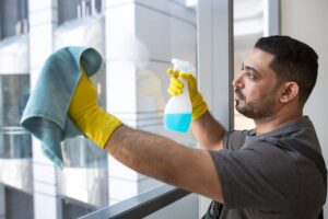a man cleaning glass with giving tips for using microfiber cloths effectively